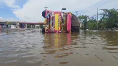 Truk Logistik Terguling di Jalur Pantura Kaligawe Semarang Setelah Nekat Terobos Genangan Banjir
